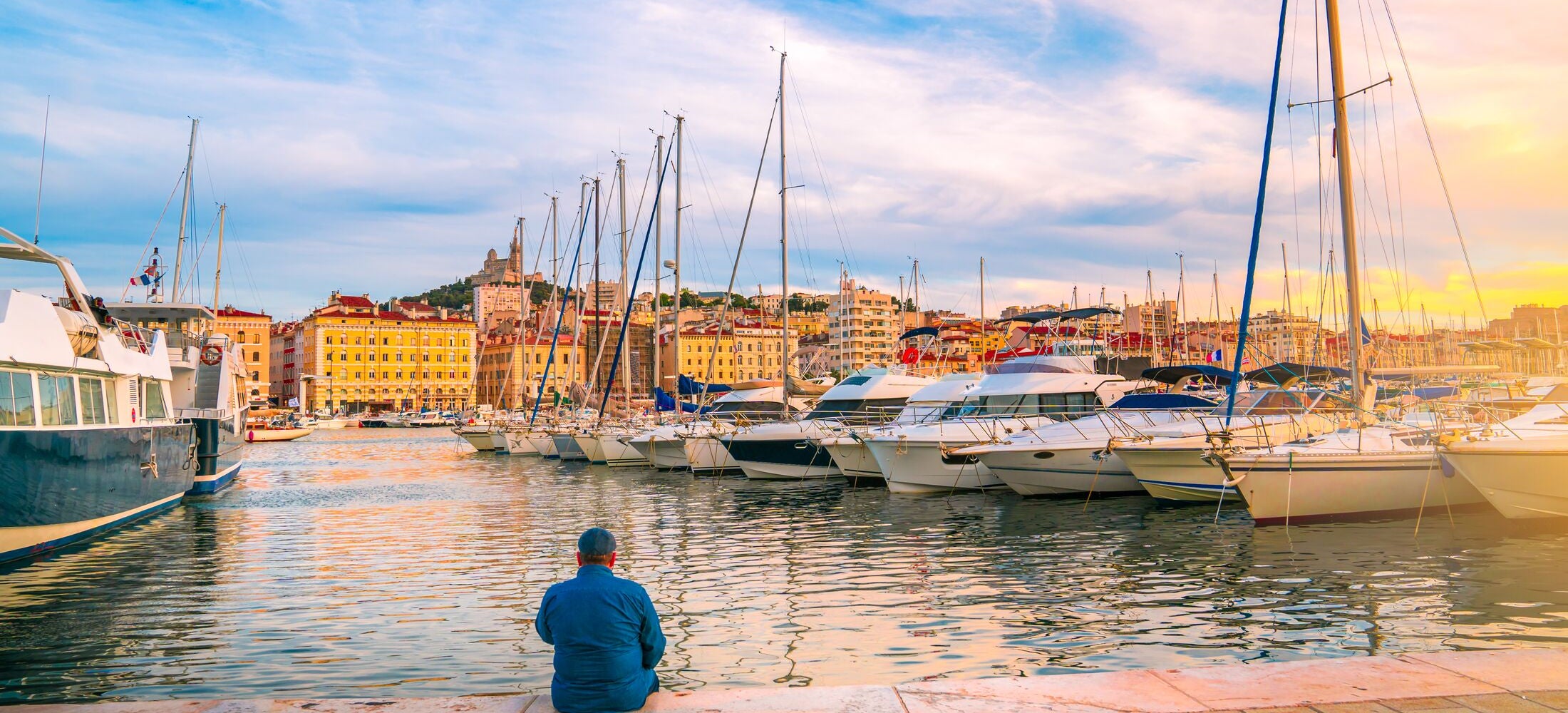 Man sitting on the wooden pier at the river.