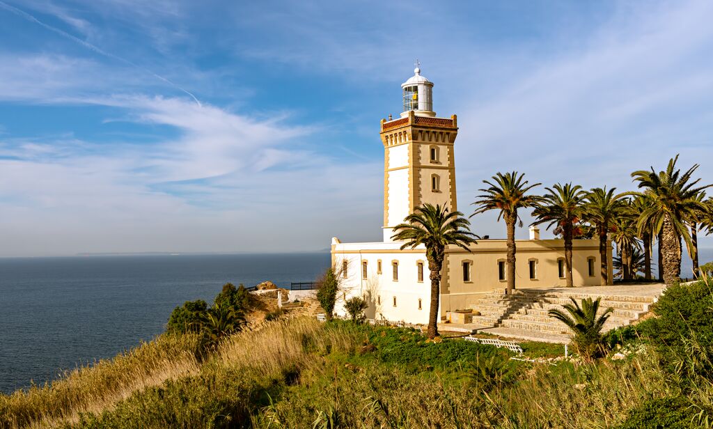 Un phare sur une colline avec des palmiers à Tanger