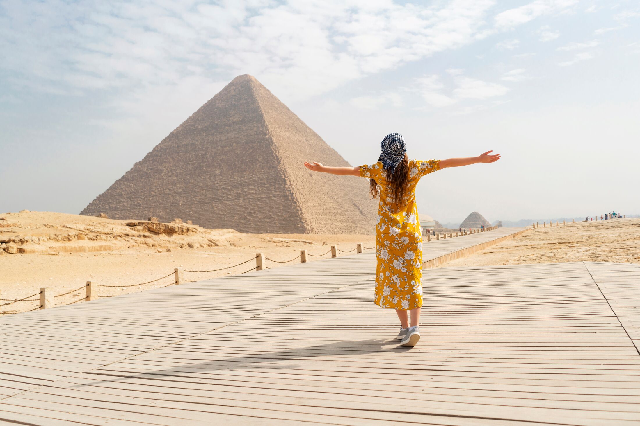 Rear view of a female tourist enjoying a tour to the Pyramids of Giza in Egypt.