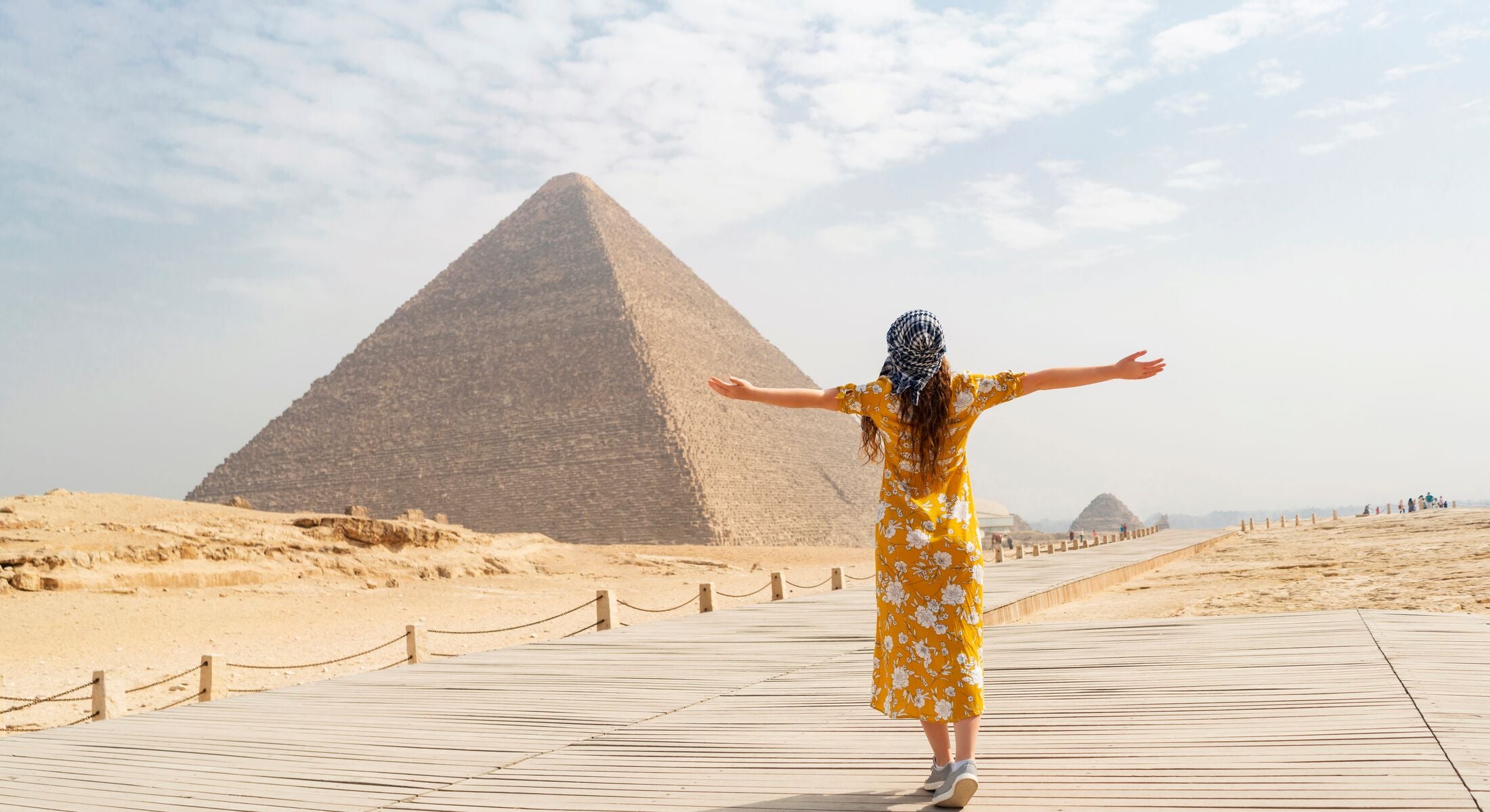 Rear view of a female tourist enjoying a tour to the Pyramids of Giza in Egypt.