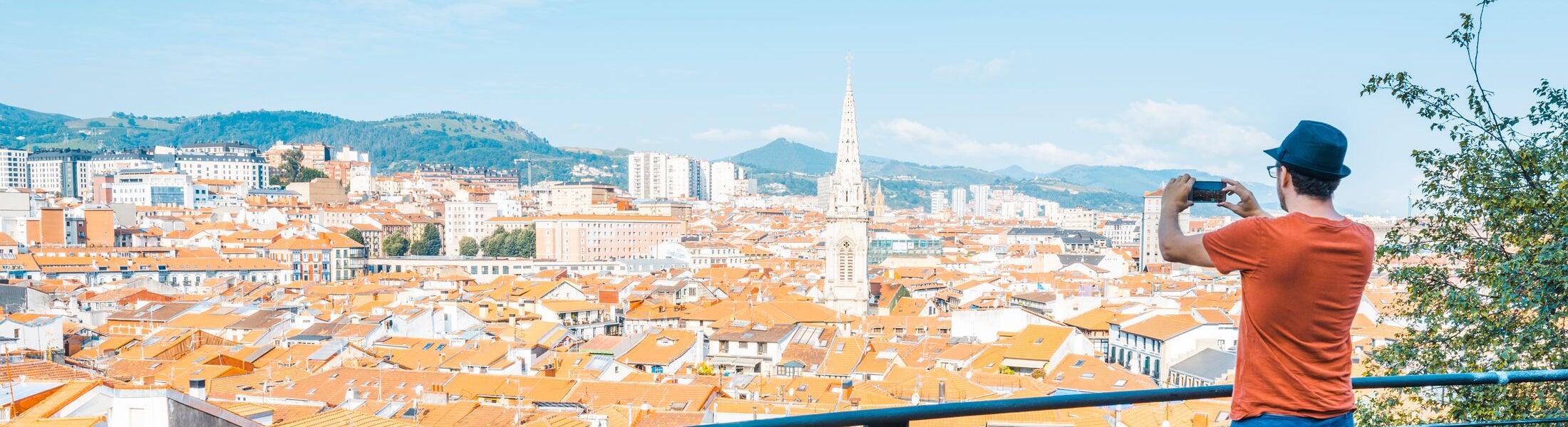 One man taking snapshot from a viewpoint over the old town (Casco Viejo) in Bilbao, Spain.